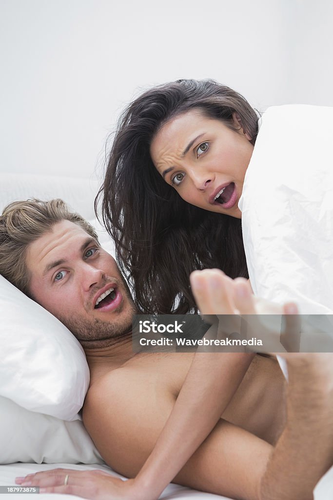 Sorprendido pareja en su cama - Foto de stock de Acostado libre de derechos
