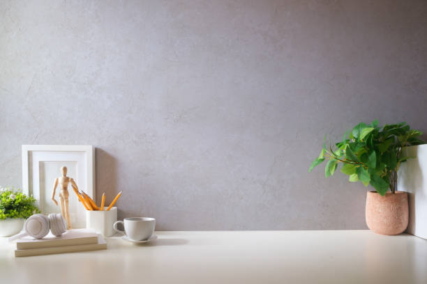 istock Creative designer workplace with picture frame mock up stationery and potted plant on white table. 1879748215