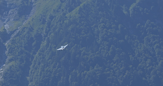 Mollis Switzerland August 19 2023: Fighter Jet in Flight close to the Mountains in a Green Alpine Valley. Eurofighter Typhoon of German Air Force. Copy Space.