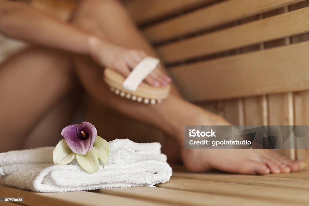 Woman massaging leg in sauna Woman massaging leg in sauna  Adult Stock Photo