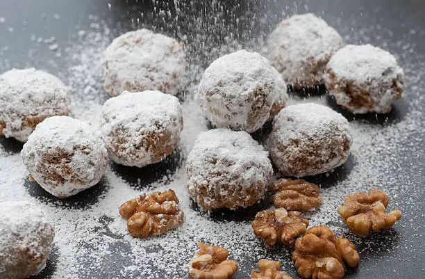 Homemade walnut snowball cookies with confectioners sugar.