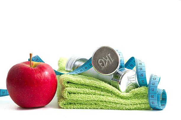 istock Dumbbells with an apple on a white background. 187980470