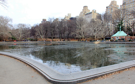 Fifth Avenue skyline, view from Central Park over Conservatory Water on a snowless gloomy winter afternoon, New York, NY, USA