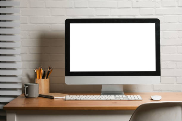istock Minimal workspace with white screen computer and office supplies on wood table. 1879810088