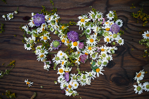 Decorative  heart and  flowers on old wooden background
