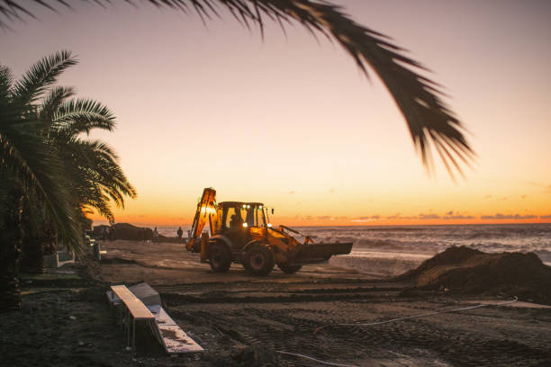 Tractor on sea shore cleaning beach after storm