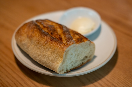 Bread with butter served on plate, on the table in the restaurant