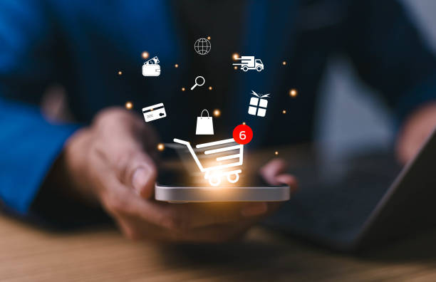 istock Businessman using smartphone with virtual graphics with business ecommerce and trolley cart icons, Technology online shopping business concept. Internet network online shop store. Notification alert. 1879832196