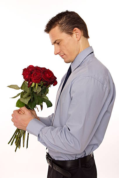 istock Young man looks on bouqet roses. 187986526
