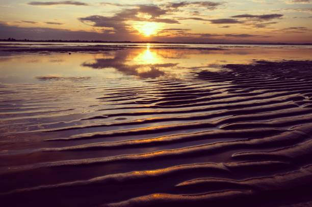 istock Sand waves, also known as sand ripples pictured during sunset across a calm sea at West Wittering beach, England 1879871379