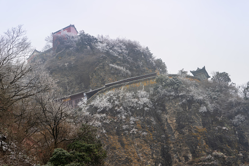 Ancient buildings in China's Wudang Mountains are elegantly decorated with a layer of snow, presenting a harmonious blend of nature and architecture.