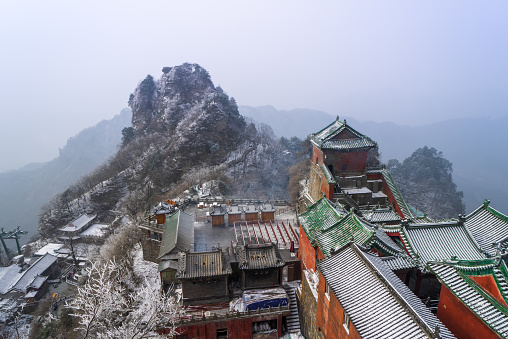 Ancient buildings in China's Wudang Mountains are elegantly decorated with a layer of snow, presenting a harmonious blend of nature and architecture.