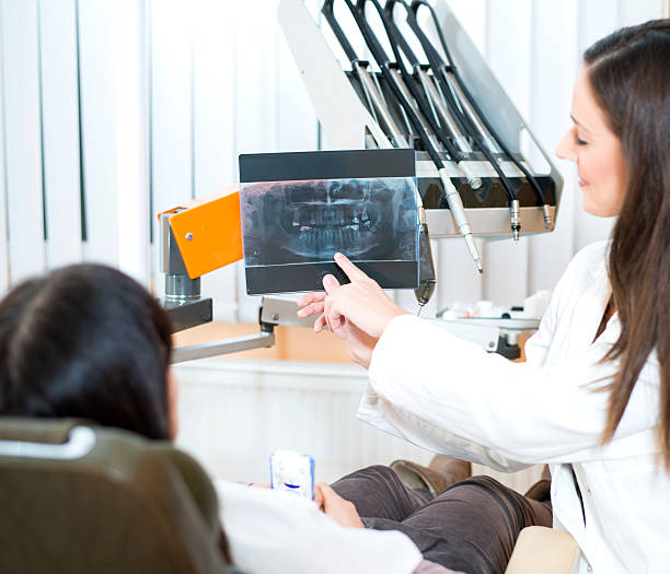 istock Dentist Showing Female Patient Dental X-rays 187988847