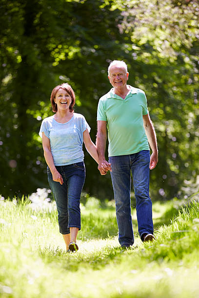 istock Senior Couple Walking In Summer Countryside 187990481