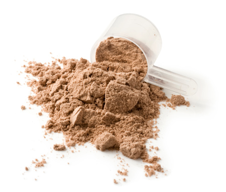 Protein powder and measuring scoop on a white background. Usually mixed with water or milk as a nutritional supplement.
