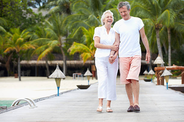 istock Senior Couple Walking On Wooden Jetty 187993059