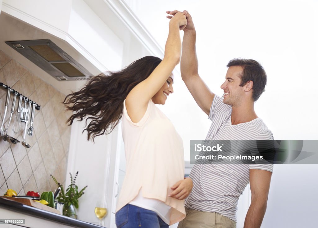 He brings out my playful side! A young couple playfully dancing in the kitchen Dancing Stock Photo