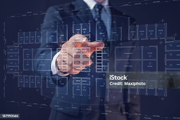 Businessman Pointing A Display With An Office Architecture Interactive Blueprint Stock Photo - Download Image Now