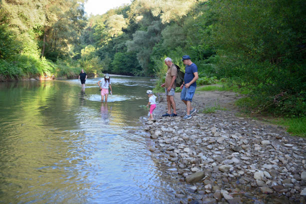 istock A family walks in a shallow river towards a camping beach 1879957246