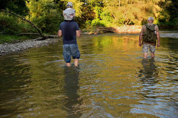 istock A family walks in a shallow river towards a camping beach 1879959298