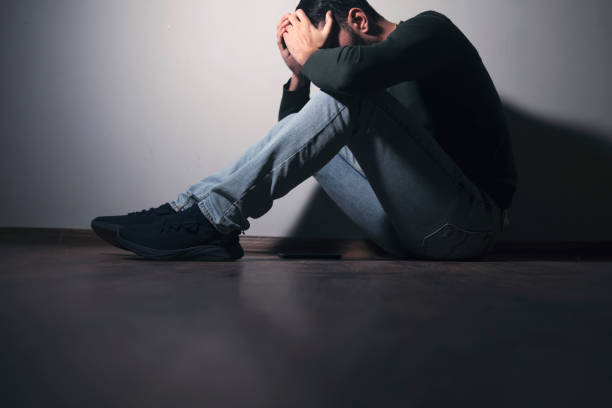 istock sad man sitting hand in face 1879989396