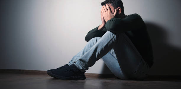istock sad man sitting hand in face 1879989400
