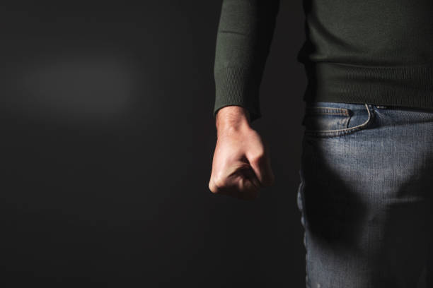 istock angry man fist on black wall background 1879996482