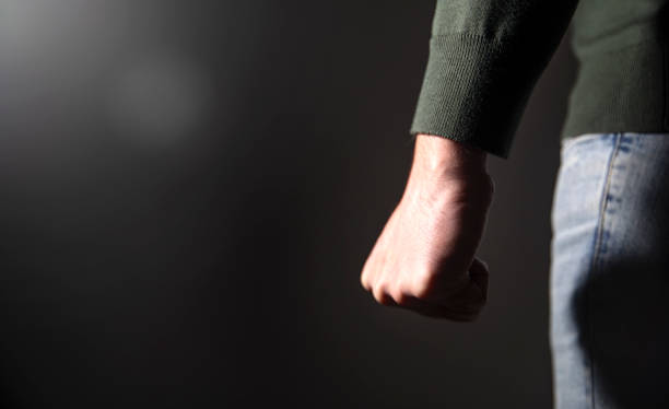 istock angry man fist on black wall background 1879996497