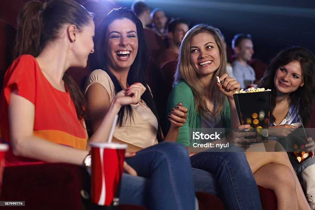 Happy girls in multiplex movie theater Happy girls sitting in multiplex movie theater, talking, laughing.. Movie Theater Stock Photo