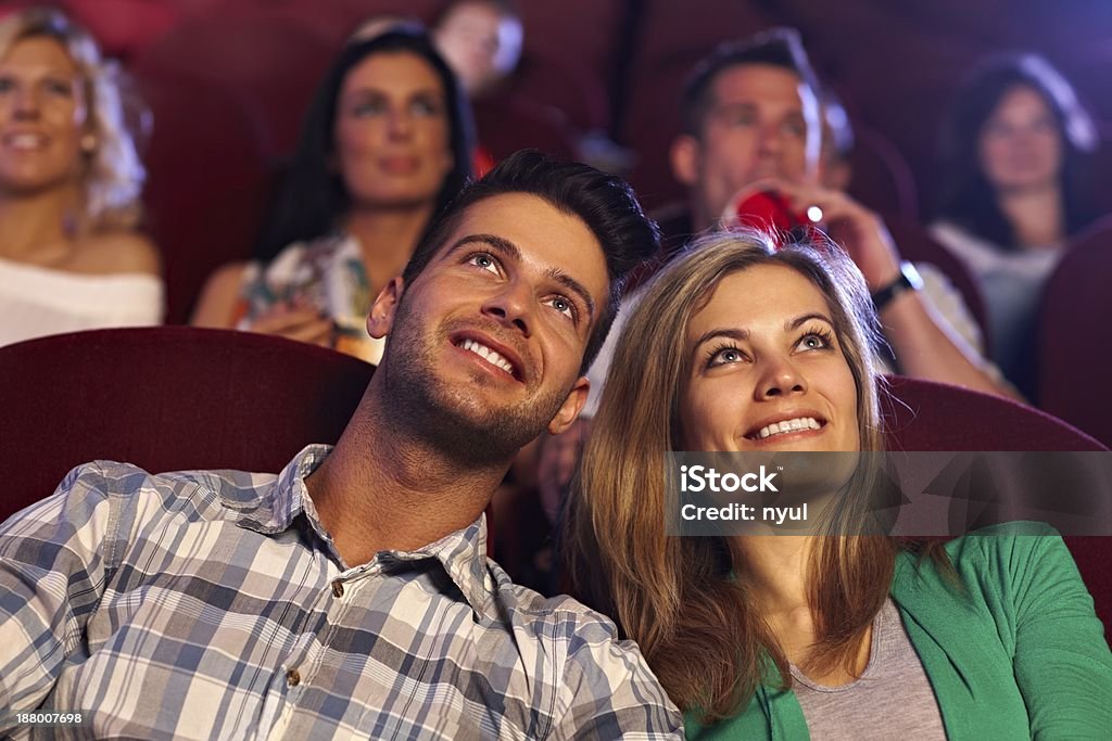 Happy couple watching movie in cinema Happy young couple watching movie in cinema, smiling.. 20-29 Years Stock Photo