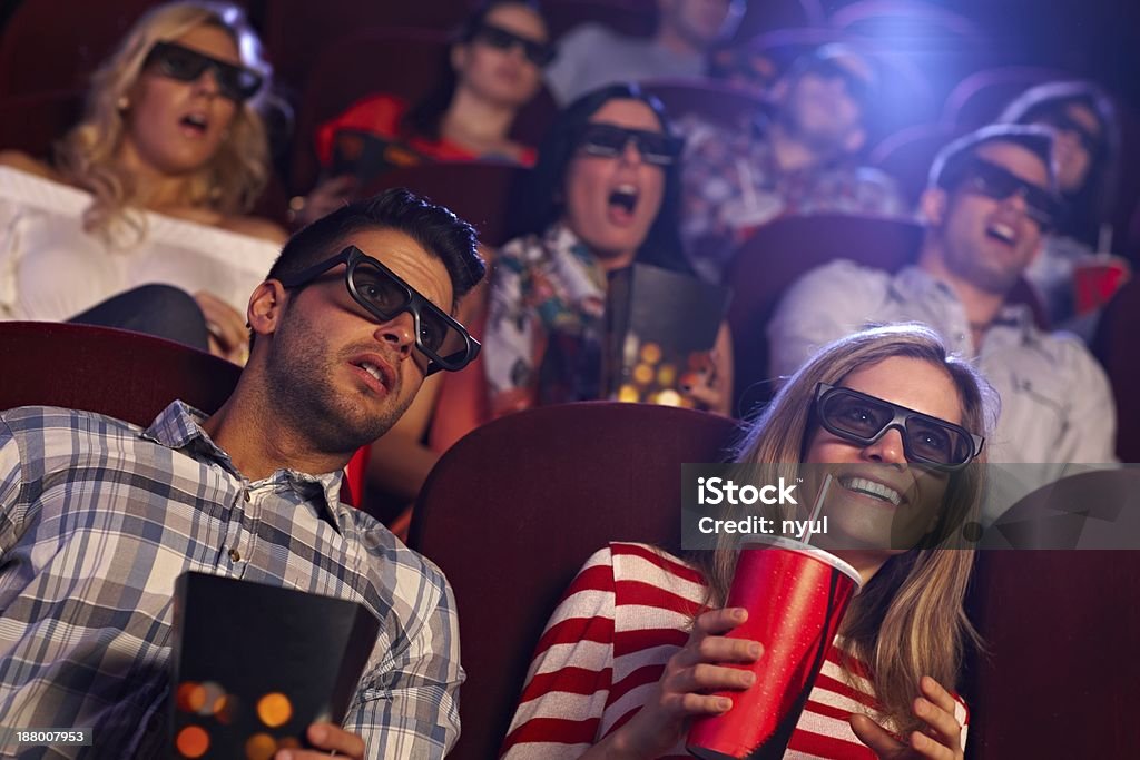 Audience watching 3D film at cinema Young people sitting at cinema, watching 3D film, smiling.. 20-29 Years Stock Photo