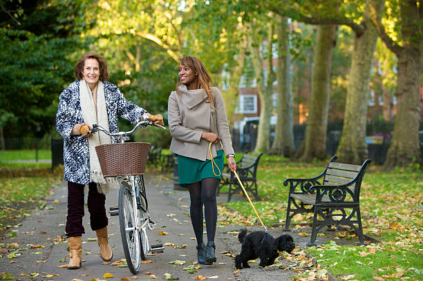 istock Two female friends talking together whilst walking through a park. 188012392