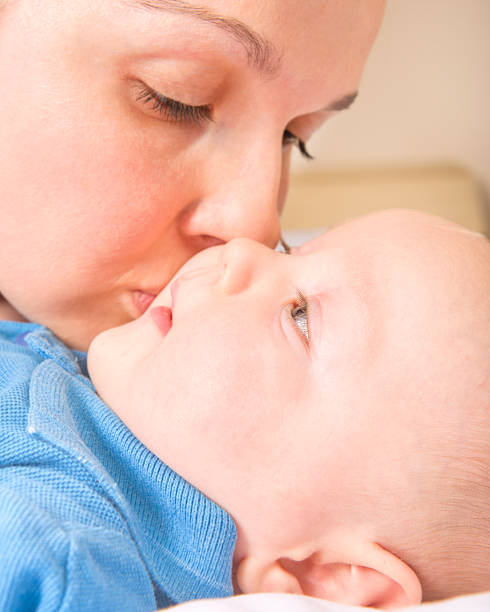istock mother kissing baby 188013542