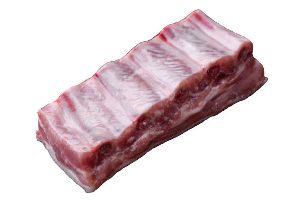 Raw pork ribs with salt, spices and herbs on textured concrete background