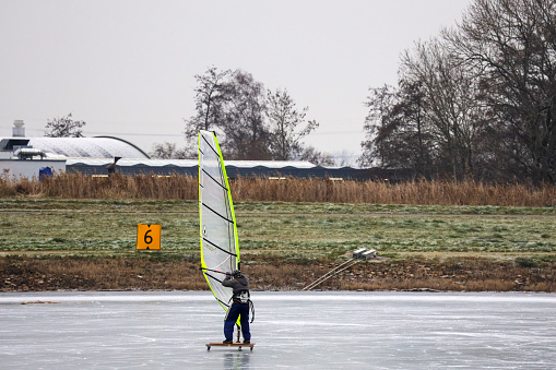 Surfing and kite surfing on skates on ice in the Eendragtspolder in the Netherlands