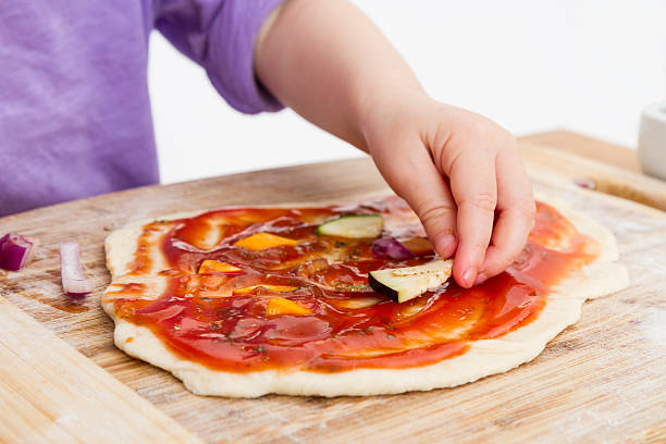 hand of cld making fresh pizza stock photo