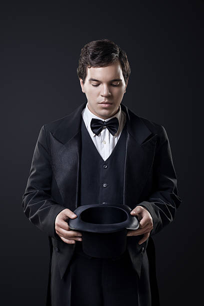 istock magician showing tricks with top hat isolated on dark background 188017423
