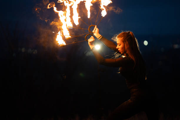 istock Young woman making performance with fire at night. 1880180182