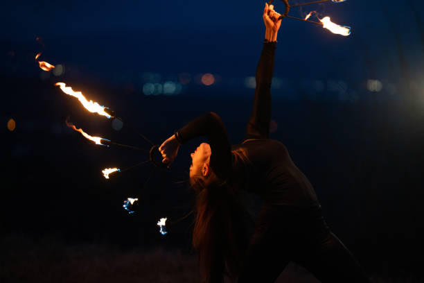 istock Young woman making performance with fire at night. 1880182722
