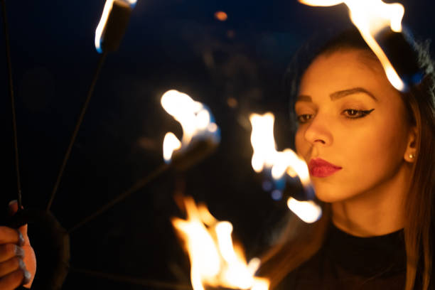 hermosa, mujer joven que realiza la danza del fuego al aire libre - traditional festival juggling women performer fotografías e imágenes de stock