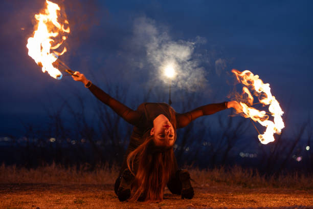 istock Female fire show performer at night 1880197453