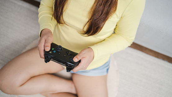 Young Asian woman gamer controller video console playingÂ holding hobby playful Online Video Game enjoyment eSport Cyber Games Internet.