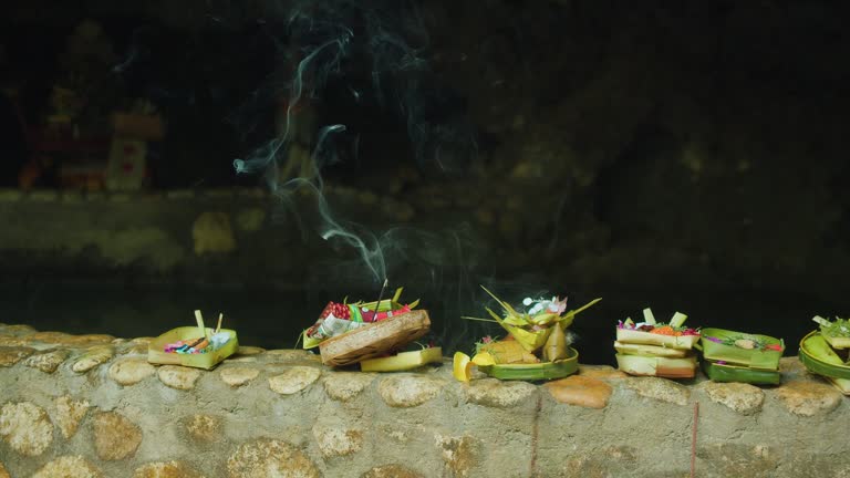 Wicker baskets with offerings to Hindu God and burning aroma sticks outdoors