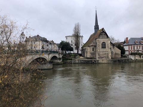 Une église et un pont de pierre sur la rivière Yonne, à Sens, en France