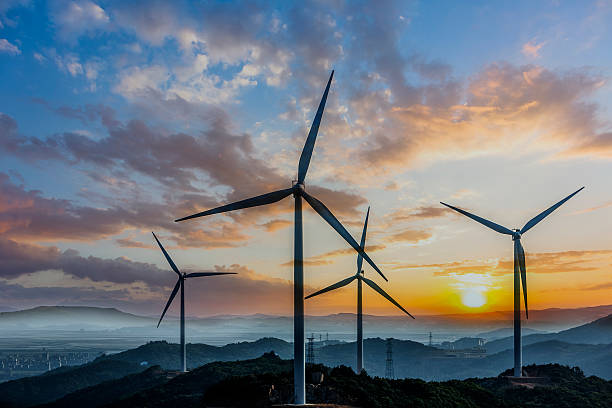 wind turbine and electrical towers on sunset