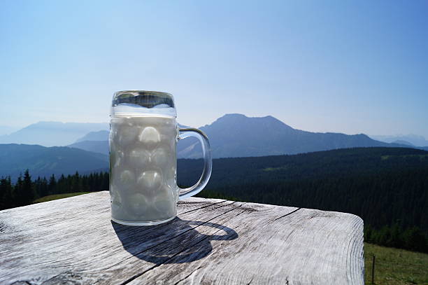 A large glass of fresh buttermilk on the Bavarian alpine pasture, with mountain views