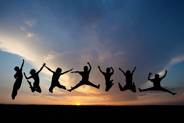 istock silhouette of friends jumping in sunset 188046743