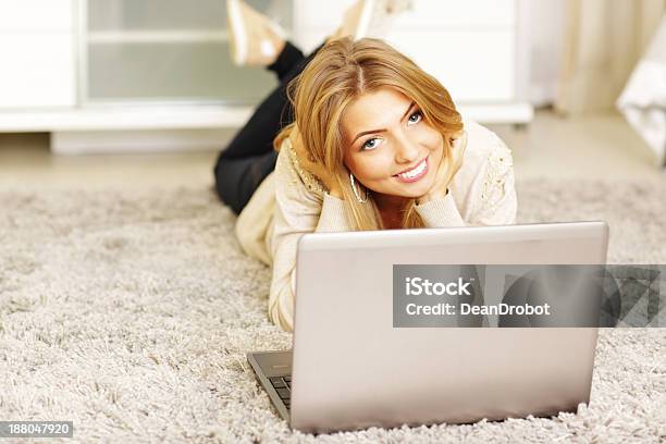 Happy Young Woman With Laptop Lying On The Carpet Stock Photo - Download Image Now - Adult, Adults Only, Beautiful People