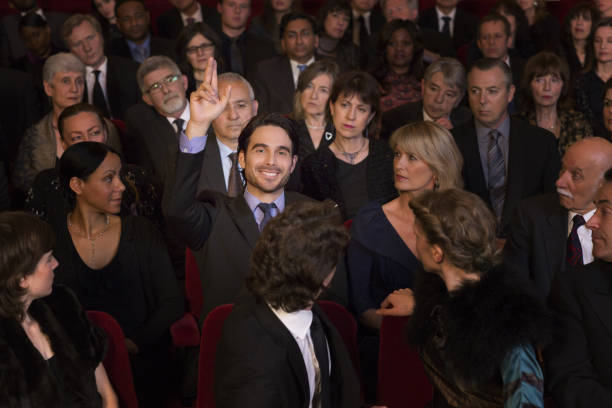 istock Man raising hand in theater audience 188051591