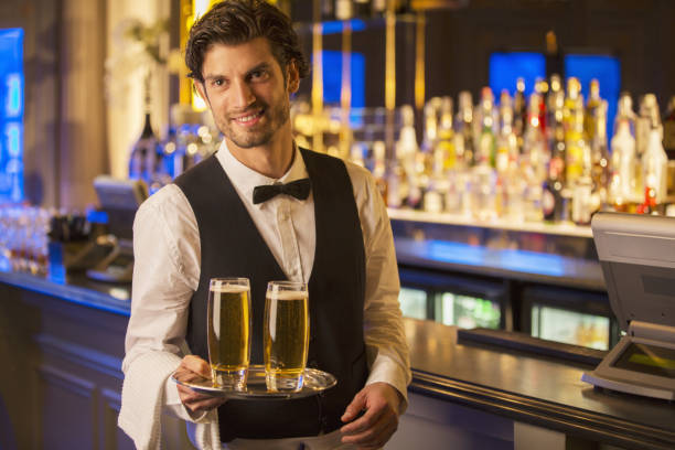 istock Portrait of well dressed bartender carrying beers on tray 188051612